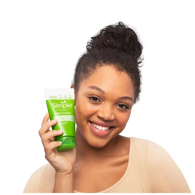 Women holding bottle next to her face and smiling